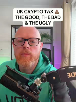 A man with a shaved head, glasses, and a red beard is speaking into a microphone. Above him is a white text box with black text. The background is a blurred image of an indoor setting.