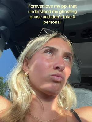 A selfie taken from inside of a car features a young woman with long blonde hair. She looks upwards with a slightly distressed expression. Text is overlaid at the top which reads, "Forever love my ppl that understand my ghosting phase and don't take it personal".