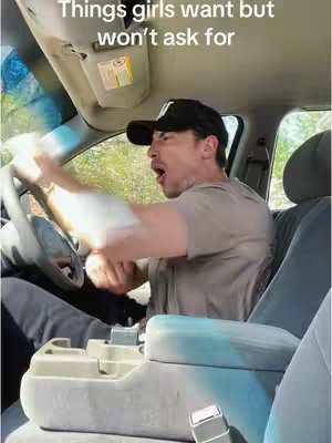 The cover image shows a man sitting in the driver's seat of a car, mid-action with an open mouth and exaggerated expression. He wears a black baseball cap with a logo, a light-colored t-shirt, and black pants. The car's interior is visible, including the dashboard, steering wheel, and seats, with sunlight streaming in from the front and side windows.