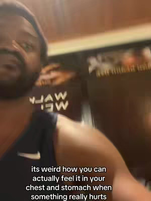A blurry shot of a man with a beard and a cap, the image is mainly of his face and upper body with a dark background and overlayed text.