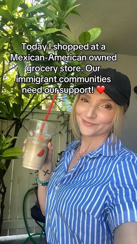 A woman with blonde hair wearing a blue and white striped shirt and a black cap poses outdoors, holding a cup. Text overlays the image, and behind her is vibrant greenery.