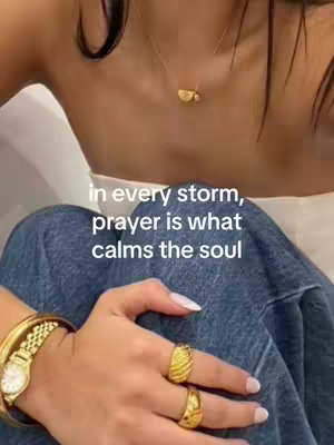 Close-up shot focused on a person's hand and part of their arms, wearing a watch with a gold bracelet and rings. The hand is resting on denim jeans. Text in white overlay is placed in the upper part of the image.
