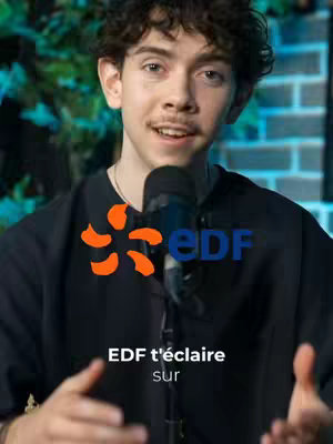 A young man with curly hair, wearing a black shirt, is holding a microphone. The image has the EDF logo and text overlay. The background is softly blurred and appears to be a combination of greenery and possibly a brick wall.