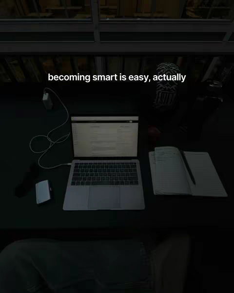 A dimly lit scene from a high-angle perspective, primarily featuring the top of a desk or table.  A laptop is open and centered, with a notepad and pen nearby. A charging cable and a small white object are connected to the laptop. The lighting suggests a dark, moody setting, potentially a nighttime study environment. The text overlay provides a hook to the video's topic.