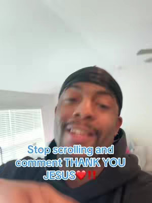 A selfie-style video cover image featuring a Black man with a durag. He is smiling and looking at the camera, with text overlaid in a blue box urging viewers to comment "THANK YOU JESUS". The background appears to be a room interior, partially out of focus.