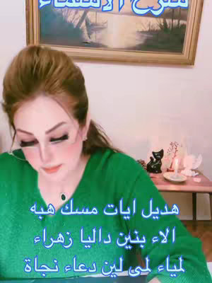 A woman with dark hair and makeup poses for the camera. She wears a green sweater. Text appears on the bottom of the image.