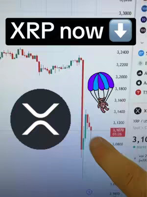 The cover image shows a computer screen displaying a stock chart with a downward trend, overlaid with the text "XRP now." The XRP logo is prominently displayed. A finger is pointing at the chart. A cartoon parachute character is also featured.