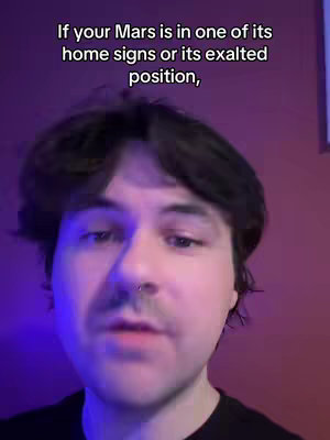 The image is a selfie-style video shot of a person with dark hair and a slight mustache, centered in the frame with a purple and red gradient background. The person has a subtle piercing in their nostril and is looking slightly upwards with their mouth closed, the lighting is coming from the bottom with a slight glow. Text overlays and is displayed at the top of the image.