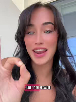 The cover image is a close-up shot of a woman with long, dark hair and a clear complexion. She is smiling with her mouth open, showing teeth, and her eyes are a light blue/green. She's gesturing with her right hand, holding up her index finger and thumb in an 'okay' sign. The background is out-of-focus and appears to be a window view. Overlayed text at the bottom of the frame reads 'JUNE 11TH BECAUSE'.