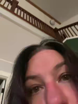 The cover image captures a close-up perspective, focusing mainly on a person's eyes and part of their face from a low angle. The lighting is soft and natural, highlighting the facial features. In the background, a wooden structure and a partial view of a flight of stairs are visible, suggesting an indoor domestic setting. The overall composition is intimate and slightly distorted due to the close-up shot.