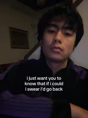 The cover image shows a young Asian man looking directly at the camera. He has dark hair and is wearing a dark purple or black jacket. The background is dimly lit and suggests an indoor setting. Text is overlaid on the image in a sans-serif font in white, expressing a longing sentiment.