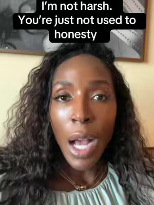 A close-up of a Black woman with long, wavy hair. She is looking directly at the camera with an open mouth as if speaking. The background is blurred, but appears to be an interior space with a picture frame on the wall. Text overlays the top of the image.