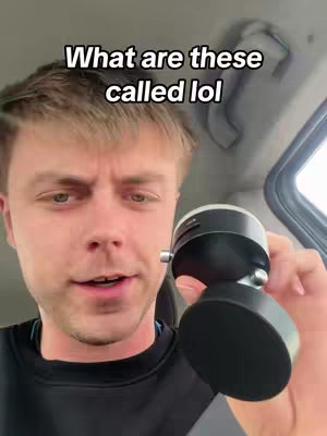 A man is inside a car holding a black object, with text overlayed that says, 'What are these called lol.' The man is fair-skinned, with short, light brown hair. He is looking at the camera and speaking. The car interior is visible.