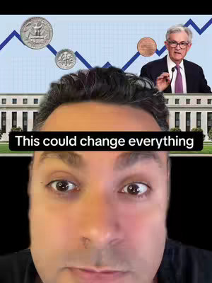 The video cover image is a selfie-style composite. In the foreground, the creator's face is visible from the eyes down, set against a background that blends several elements: a line graph forming an upward trajectory, the image of Jerome Powell, and various coins superimposed. At the top, a few coins are floating, and the image shows the Federal Reserve building behind a line graph. The color palette is dominated by cool tones – blues and grays – with pops of color from the coins and images.