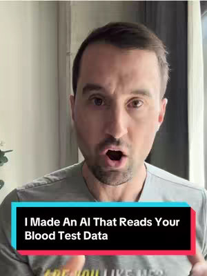 A man with short dark hair and light skin is centered in the frame, looking directly at the camera with a slightly open mouth. He is wearing a gray t-shirt. Behind him are blurred white walls and natural light coming from what seems to be a window with a curtain. A rectangular text overlay at the bottom reads, in white font, 'I Made An AI That Reads Your Blood Test Data.' The background of the text overlay is a gradient of teal and red.