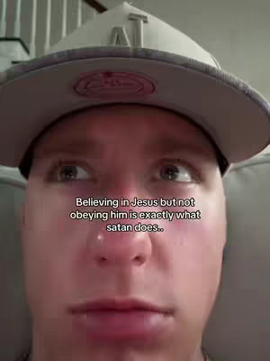The cover image displays a close-up shot of a young man's face from a low angle. He is wearing a gray baseball cap, which is slightly angled. The man has fair skin and brown eyes. The image has overlaid text in a white font that reads, "Believing in Jesus but not obeying him is exactly what satan does.." suggesting the video's religious message.