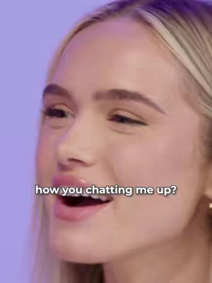 A close-up shot features a fair-skinned woman with blonde hair and light pink lipstick partially covering her face. The woman's mouth is open. Text in a white box overlay reads 'how you chatting me up?'. The background is a solid purple.