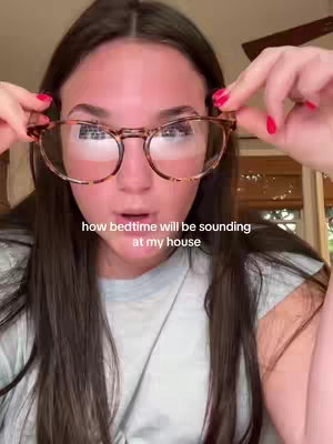 A young woman with long brown hair and glasses is looking directly at the camera. She is holding her glasses with both hands. The text overlay says 'how bedtime will be sounding at my house'.