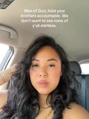 A woman with long, dark wavy hair is seated in the front seat of a car. The text overlayed on the image reads, 'Men of God, hold your brothers accountable. We don't want to see none of y'all shirtless.' She's looking directly at the camera with a neutral expression. The background suggests a sunny day outside, with the car's interior visible.