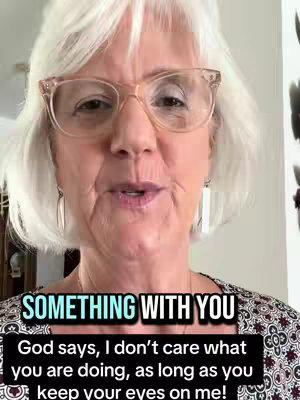 A woman with short white hair and glasses is speaking, the text overlay is below her.