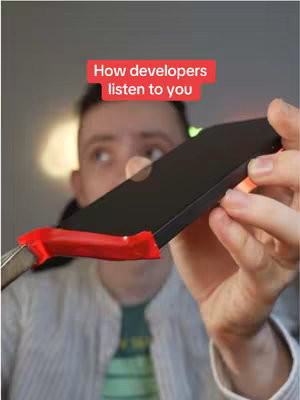 A medium shot features a man holding a black smartphone with an orange highlighting along the edge. The phone is held next to a silver blade wrapped in red tape, creating a visual metaphor. Above the man's head, the text overlayed suggests the video's theme of privacy and technology.