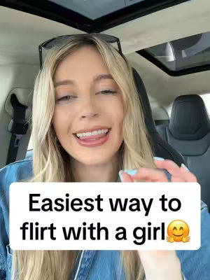 A woman with long blonde hair sits in a car, looking at the camera with a smile and her tongue out. A text box below her reads, "Easiest way to flirt with a girl" with a smiling emoji.