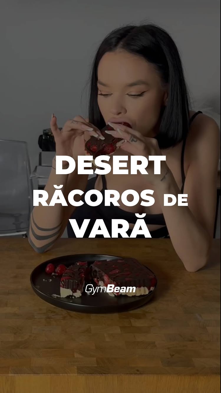 The cover image showcases a woman holding and eating a slice of a chocolate dessert. The dessert, presented on a wooden table, appears to have multiple layers and includes fruit, likely berries. The woman is taking a bite, with a tattoo visible on her arm. Text overlays on the image read "DESERT RACOROS DE VARA". The GymBeam logo is also present.