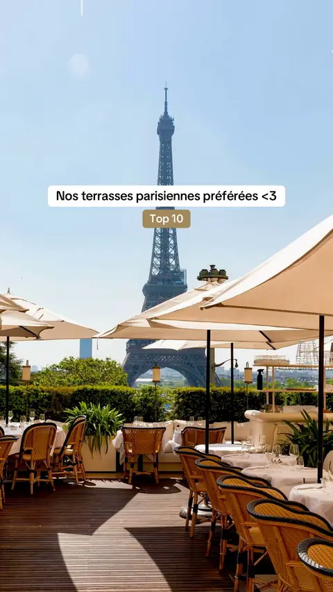 The cover image showcases a sunny outdoor scene with a dining area, featuring tables with white tablecloths and chairs. The Eiffel Tower stands prominently in the background under a clear blue sky. Beige sun umbrellas provide shade. The layout of the image is balanced with the Eiffel Tower as the central focal point.