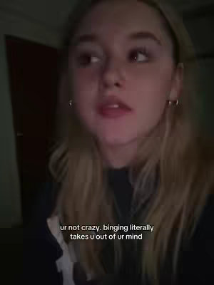 A young woman with long blonde hair is looking off to the side in a close-up shot. The image is lit with soft, indirect light, suggesting an indoor setting. Text overlayed on the image reads "ur not crazy. binging literally takes u out of ur mind."