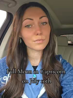 A woman with long brown hair is seated in a car, looking at the camera. Text overlaid on the image says 'Full Moon in Capricorn on July 10th'.