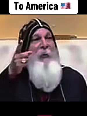 The image presents an older man, likely of Middle Eastern descent, speaking into a microphone. He has a long white beard and wears a black and white head covering. The background is a muted beige, and the text overlay at the top says "To America" along with the American flag.