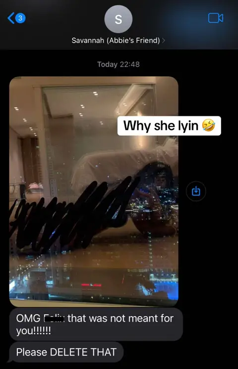 The image shows a text message conversation on a smartphone. The background is a blurred view of a city skyline at night. Overlayed on this background is a screenshot of a text messages. The text messages show part of a conversation between two people. One of the messages in the conversation has a black scribble over part of the text. Added as a hook is "Why she lyin 😂".
