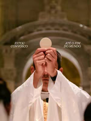 A man in a white robe holds up a communion wafer between his hands, obscuring his face. Text overlays on either side of his head read, "ESTOU CONVOSCO" and "ATÉ O FIM DO MUNDO". The background softly focuses on a church interior with arched architectural details.