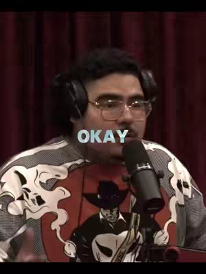 The cover image shows a man wearing headphones, glasses, and a graphic t-shirt, positioned in front of a dark red curtain. The word 'OKAY' is overlaid on the image.