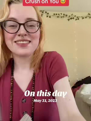 A woman with blonde hair wearing glasses and a maroon shirt smiles at the camera. Text overlays read "Crush on You" and "On this day May 31, 2023". The background includes a wall with leafy decorations.