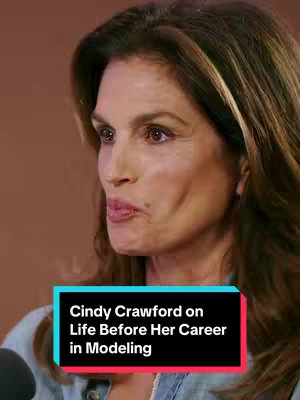 A vertical shot of Cindy Crawford speaking. She is in a medium shot, making direct eye contact with the camera and speaking. A text box near the bottom of the image reads, `Cindy Crawford on Life Before Her Career in Modeling`