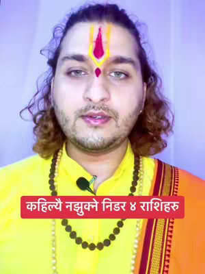 A man with light skin and curly brown hair is centered in the frame. He wears a yellow shirt, an orange scarf and a beaded necklace and a red and yellow forehead marking. Below the subject is a bright red banner with white text.
