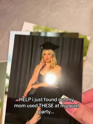 The cover image shows a hand holding a photograph of a woman in a graduation cap and gown. The photo is in color and appears to be a formal portrait against a dark curtain backdrop. The woman is fair-skinned with blonde hair. The hand holding the photo is also fair-skinned. Other photos are stacked behind the main one, creating a layered effect.