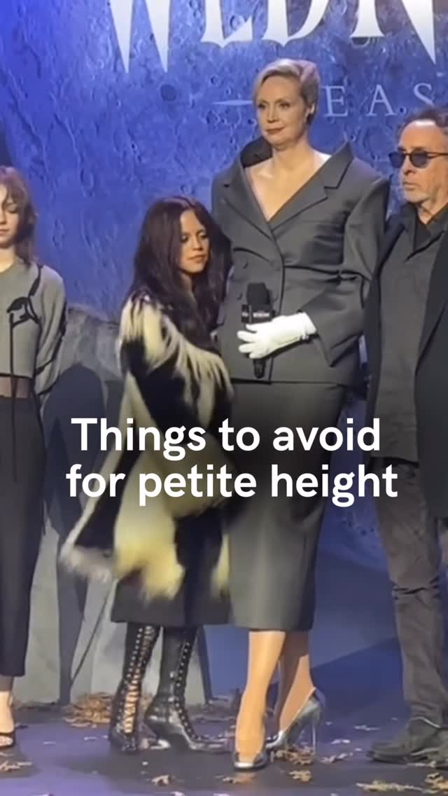 The image shows three people standing in front of a dark blue backdrop. The middle person, a person with dark hair, is wearing a black coat with white fur and black boots. The person on the right is wearing a suit coat and gray slacks. The person on the left is a female wearing black attire behind a person wearing a coat. The overlay text is: Things to avoid for petite height.