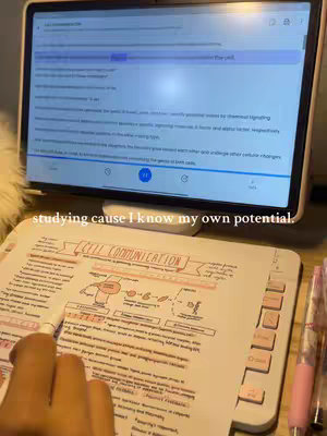 The cover image showcases a setup for studying. A tablet displaying study notes is propped up in the top portion, with a handwritten notebook in the foreground. A hand with a pen is visible writing on the notebook. The color palette is dominated by white, pink, and light blue, with the lighting appearing soft and natural.