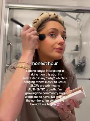 A woman in a bathroom applies blush, with rollers in her hair. Text overlay with a personal essay.