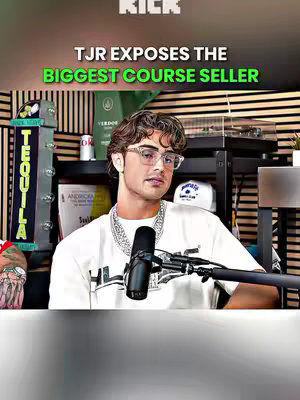 A man in glasses and a white t-shirt sits, appearing to be in a podcast studio. Text overlayed reads 'TJR EXPOSES THE BIGGEST COURSE SELLER' with a vibrant green highlight on the title. The background shows studio equipment and a background of vertical wooden slats.