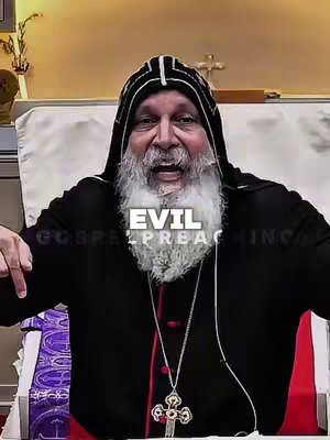 An individual in a black hood with a white beard is making a statement while using gestures. The word "EVIL" is overlaid in white text in the middle of the image.