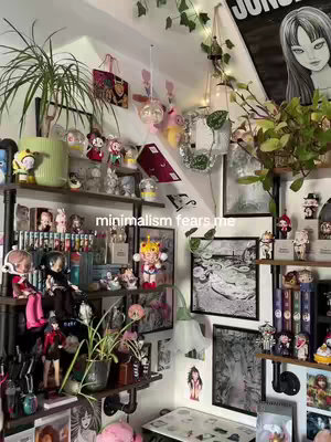 A photograph showcasing a room filled with collectibles and decor, organized on shelves and walls. The composition is dense, with a variety of items including figurines, framed artwork, plants, and framed images. Predominantly, the room is white and lit with natural light. The arrangement suggests a personal space with a strong emphasis on the owner's interests.