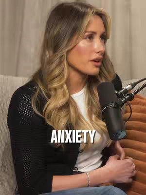 Image of a woman in a black top and a white shirt, sitting on a sofa talking into a microphone. The hook text "ANXIETY" is overlaid on the screen.