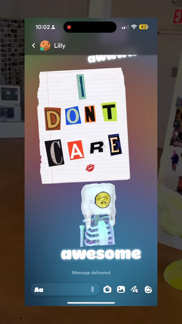 The cover image is a screenshot of an iPhone screen displaying a text message conversation within an app. The background is a blurred gradient of blue and purple. The top displays the time, battery level, and network status. At the center, a torn piece of lined paper features the phrase "I DON'T CARE" with letters cut out from different fonts. Below, there is an illustration of a skeleton with a smiley face on its head, against a cloud-like structure, and the word "awesome" written in white font. At the bottom is a text input field with messaging icons.