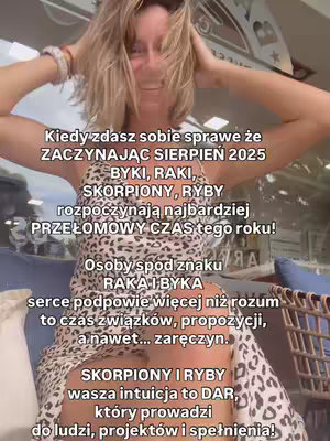 A woman is smiling widely with both hands above her head. She is wearing a dress with a bold leopard print pattern. The image has text overlaid in the middle of the image in a casual font suggesting it is a daily post, possibly related to astrology.