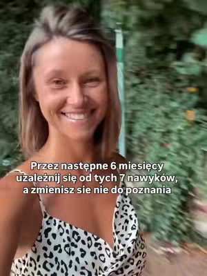 A woman is smiling and looking at the camera. She has light brown hair and is wearing a patterned top. The background is blurred and contains greenery. Text overlayed on the image.
