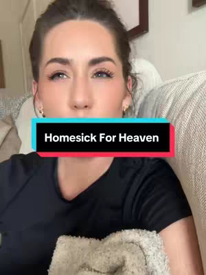 A woman with light skin and dark hair is the central focus. She's seated indoors, likely on a couch, with a patterned pillow partially visible behind her. The cover image has a text overlay with words 'Homesick For Heaven' inside a rectangle of navy blue and red. The lighting appears to be natural.