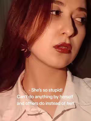 A close-up shot focusing on a young woman's face, with the right side of her face in profile and looking towards her right and upwards. She has red hair and wears a white shirt. Text overlays are at the bottom. The lighting is soft, giving the image a slightly warm and intimate feel.